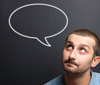 man looking at empty speech bubble because he suffers from a voice disorder